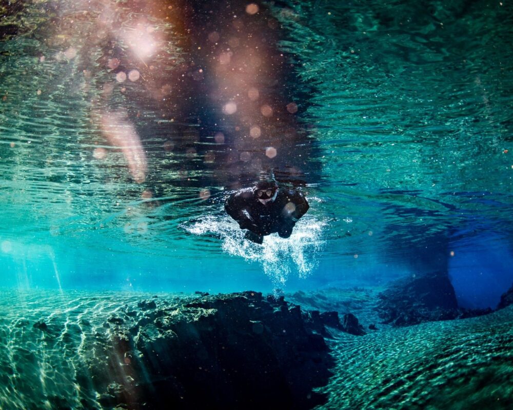 Silfra Snorkelling Tour: Float over lava and explore volcanic canyons—an adventure in Iceland's crystal-clear waters.